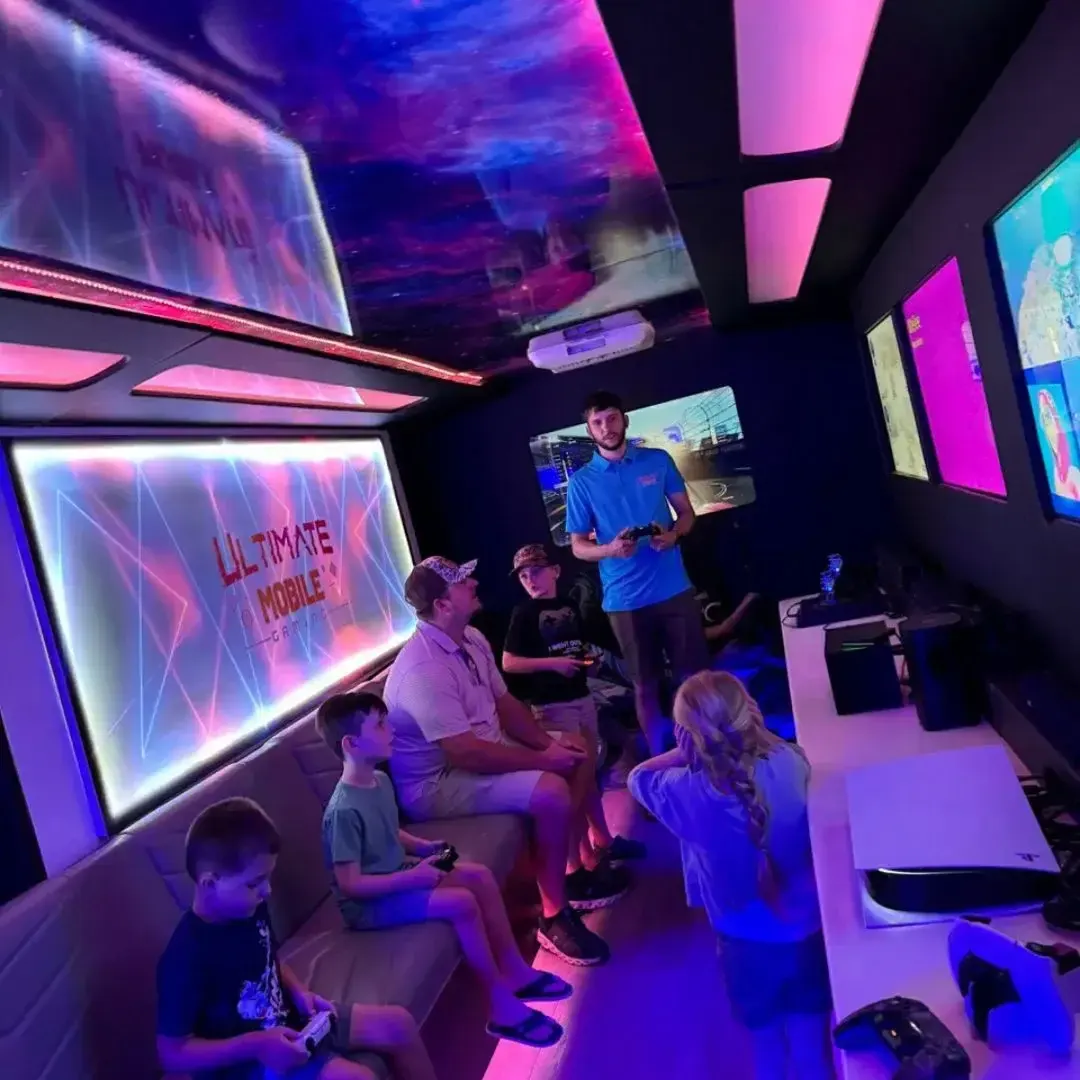 Game coach helping a family play inside the climate-controlled mobile gaming truck