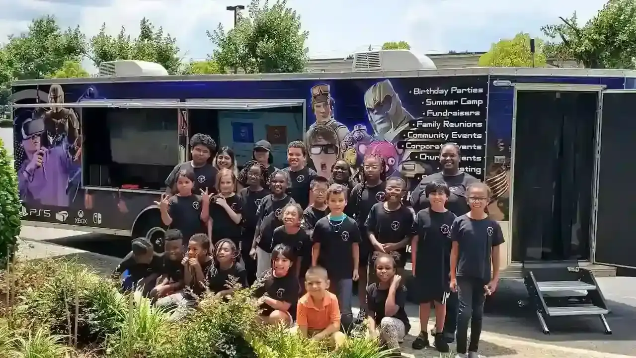 Large group of school kids posing in front of the Ultimate Mobile Gaming trailer at a community event in Northeast Georgia